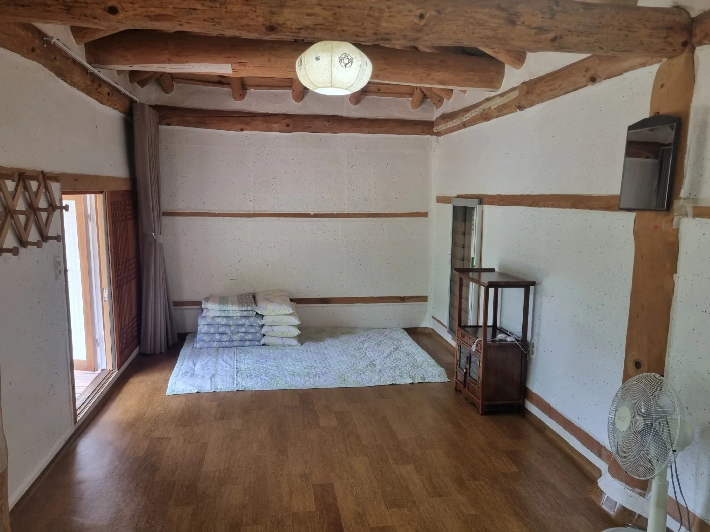 노출된 나무 들보와 온돌 바닥이 보이는 황토방 내부